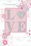 This image features an anniversary card that seems ready to accompany a romantic flower delivery across Stratford, its design imbued with tender detail. The focal point is the word LOVE, printed in bold but graceful uppercase letters that are slightly raised, making them pleasingly tactile under the fingertips. These letters are dusted with a frosty glitter finish, shimmering in blush pink, pearl white, and specks of silver, like the soft glow of twilight over the Olympic Park. The rest of the card is washed in a delicate pastel pink, smooth and even, forming a serene canvas. Flowing in from the edges is a constellation of stylized flowers and trailing vines. They are drawn with fine, controlled lines, while their petals carry gentle washes of blush, mauve, and creamy ivory, complemented by cool silvery-grey foliage. Here and there, tiny glints of metallic silver catch the imaginary light, echoing the sparkle of the LOVE lettering. The arrangement of these blooms is suggestive of a florist's plan for a hand-tied bouquet: clusters of blossoms, soft negative spaces, and sweeping stems, much like the anniversary designs delivered to homes near Stratford station or the quieter streets leading towards Plaistow. Small decorative accents-dots, curls, and leaf tips-are sprinkled across the card's surface, evoking falling petals or confetti. A heartfelt message in an elegant script font reinforces the theme of enduring affection and shared journeys. The overall effect is gentle and intimate, with colour, texture, and composition combining to create a paper expression of love that would sit beautifully beside a vase of fresh anniversary flowers.